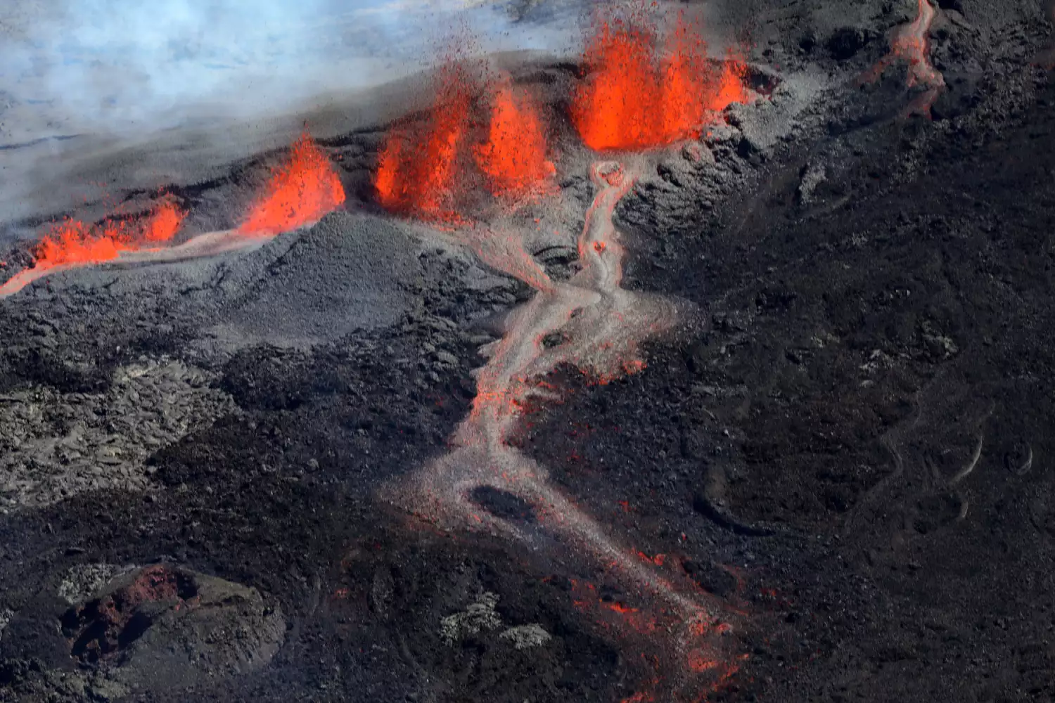 熔岩从 Rivals 火山口喷出，顺着 Piton de la Fournaise 的南面流下。
